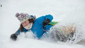 A girl sleds in Rock Creek Park during a snowstorm in Washington, DC, on January 23, 2016. A deadly blizzard with bone-chilling winds and potentially record-breaking snowfall slammed the eastern US on Saturday, as officials urged millions in the storm's path to seek shelter -- warning the worst is yet to come. / AFP / Nicholas Kamm (Photo credit should read NICHOLAS KAMM/AFP/Getty Images)